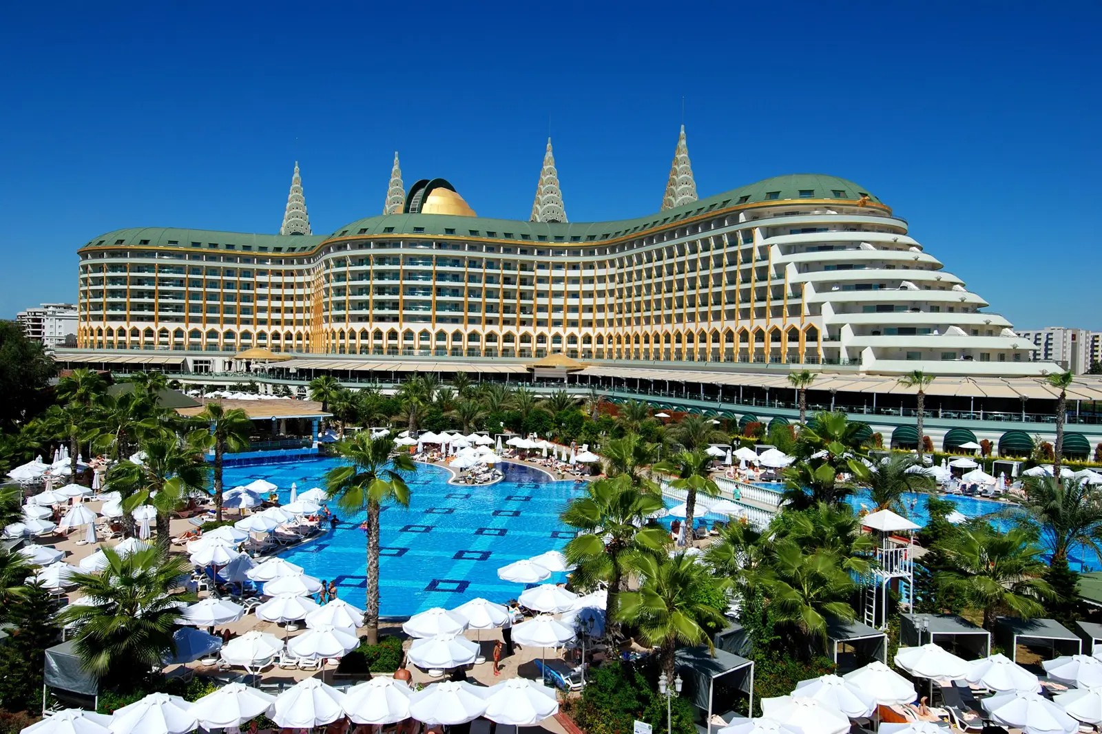 Delphin Imperial Hotel Antalya met groot zwembad, palmbomen en luxe ligbedden